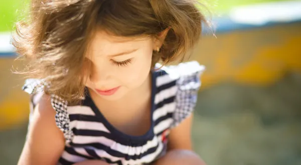 Menina bonito está jogando no parque infantil — Fotografia de Stock