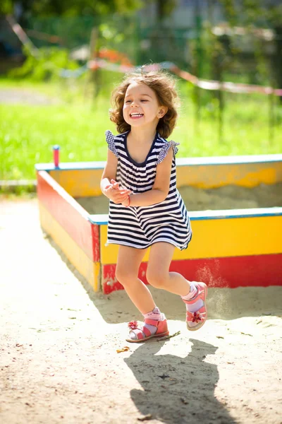 Kleines Mädchen spielt auf Spielplatz mit Sand — Stockfoto