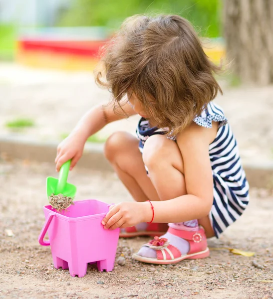 Klein meisje speelt met zand in Speeltuin — Stockfoto
