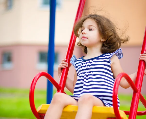 Szczęśliwa dziewczyna kołysze się w plac zabaw dla dzieci — Zdjęcie stockowe
