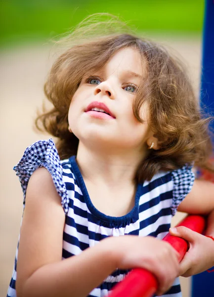 Menina bonito está jogando no parque infantil — Fotografia de Stock