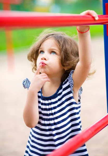 Petite fille mignonne joue dans l'aire de jeux — Photo