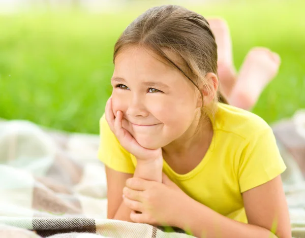 Porträt eines kleinen Mädchens auf grünem Gras liegend — Stockfoto