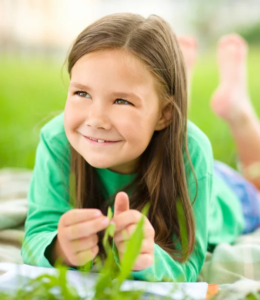 Portrait d'une petite fille allongée sur de l'herbe verte — Photo