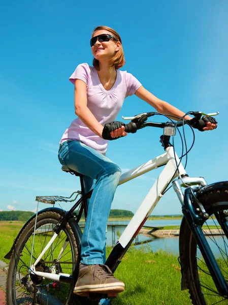 Jovem mulher está sentada em sua bicicleta — Fotografia de Stock