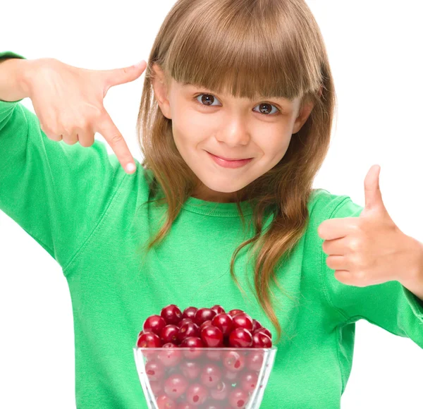 Menina bonito está comendo cerejas mostrando polegar para cima suspiro — Fotografia de Stock