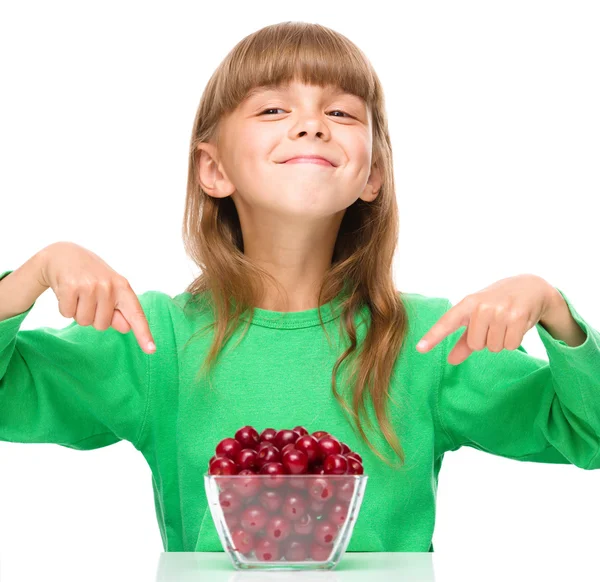 Cute girl is eating cherries — Stock Photo, Image