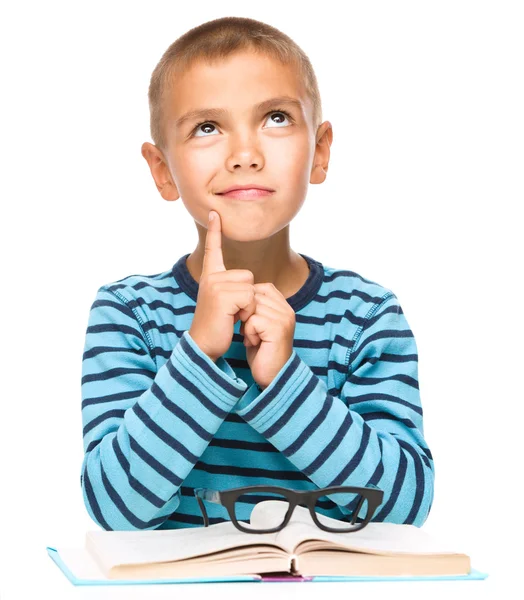 Jonge jongen is dagdromen tijdens het lezen van boek — Stockfoto