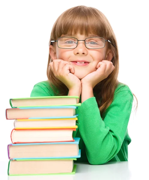 Маленькая девочка с грудой книг — стоковое фото