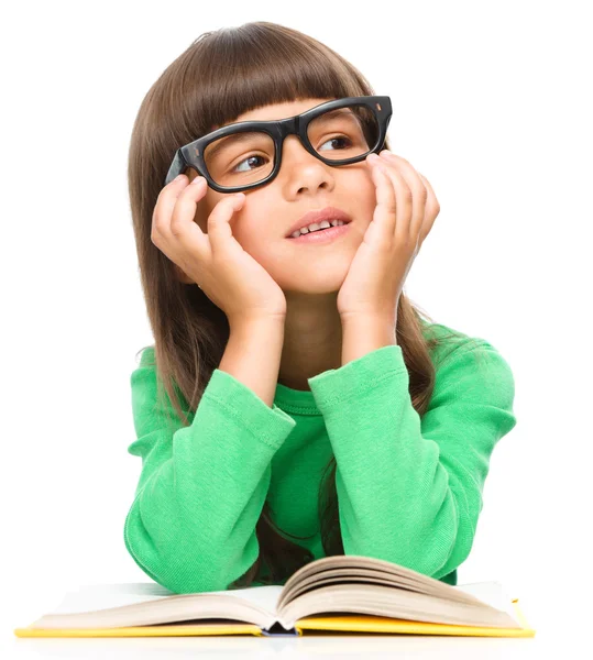 Young girl is daydreaming while reading book — Stock Photo, Image