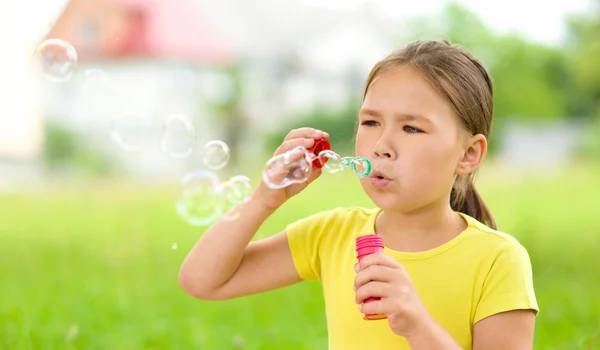 Kleines Mädchen bläst Seifenblasen — Stockfoto