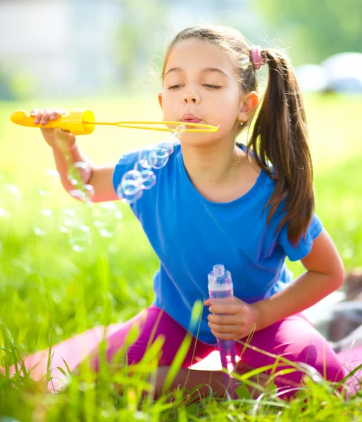 Little girl is blowing a soap bubbles — Stock Photo, Image