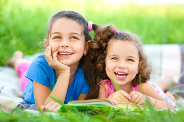 Twee kleine meisjes boek aan het lezen bent — Stockfoto