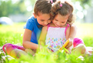 iki küçük kız kitap okuma