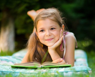 küçük kız açık havada bir kitap okuma