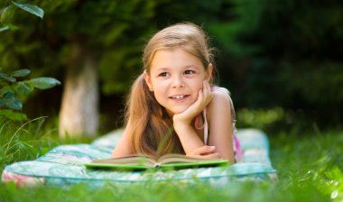 küçük kız açık havada bir kitap okuma