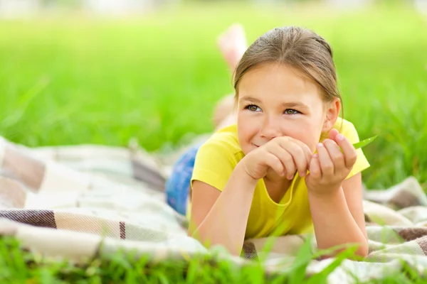 푸른 잔디에 누워 어린 소녀의 초상화 — 스톡 사진