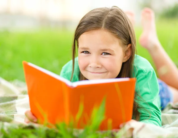 小女孩读一本书户外 — 图库照片