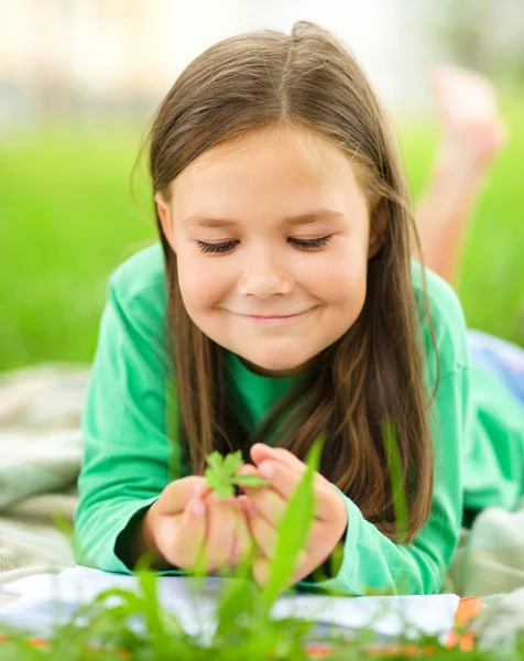Portrait of a little girl laying on green grass — Stock Photo, Image