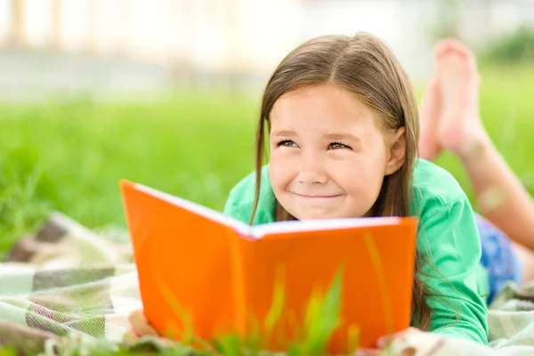 Petite fille lit un livre en plein air — Photo