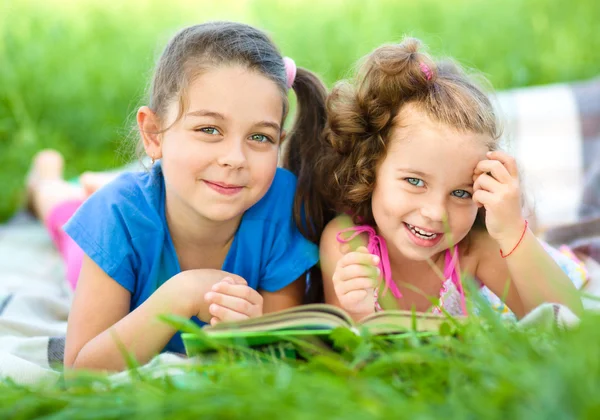 Zwei kleine Mädchen lesen Buch — Stockfoto