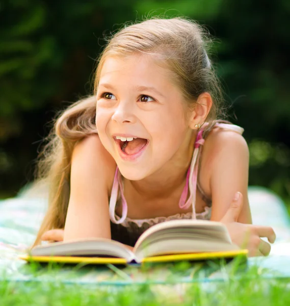 Kleines Mädchen liest draußen ein Buch — Stockfoto