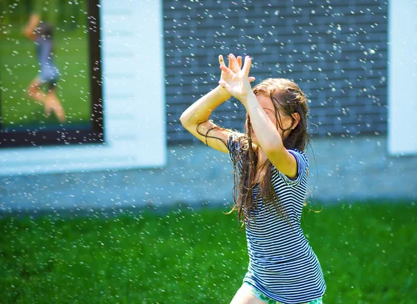 Menina feliz está jogando sob a chuva — Fotografia de Stock