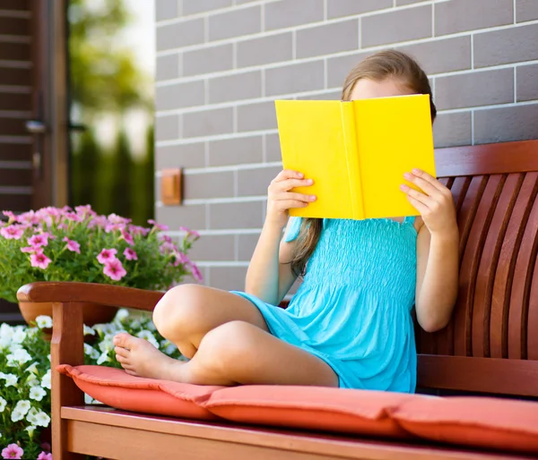 Klein meisje is het lezen van een boek — Stockfoto