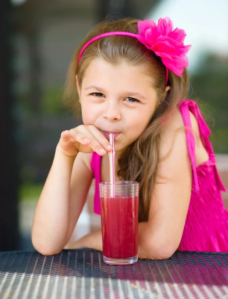 Little girl is drinking cherry juice — Stock Photo, Image