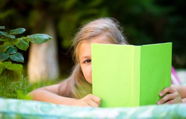 küçük kız açık havada kitap gizleme