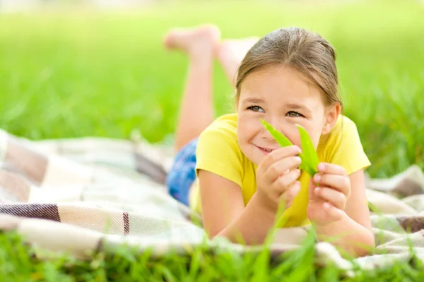 Porträt eines kleinen Mädchens auf grünem Gras liegend — Stockfoto