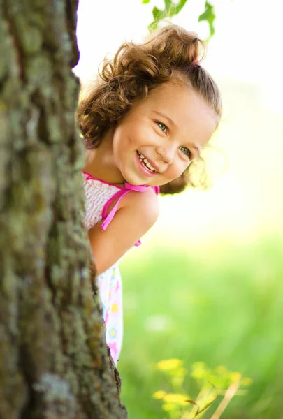 Schattig klein meisje is spelen verstoppertje en zoeken — Stockfoto
