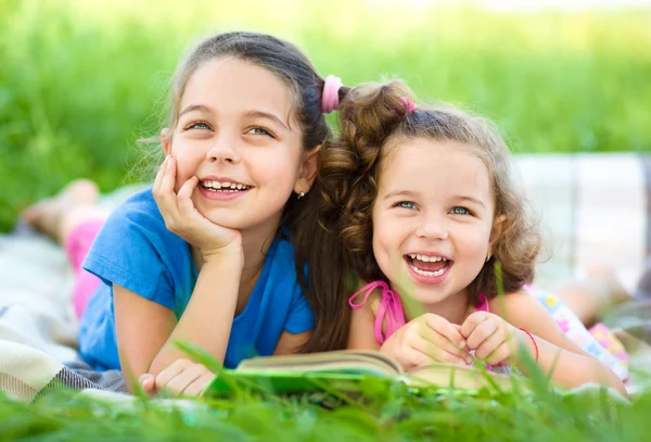 Дві маленькі дівчата читають книгу — стокове фото
