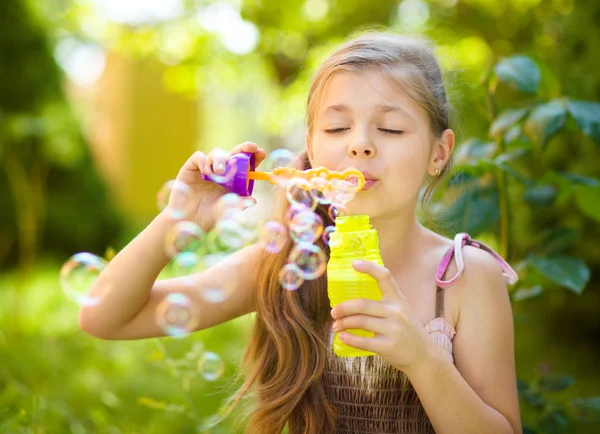 Ragazzina sta soffiando bolle di sapone — Foto Stock