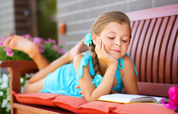 Klein meisje is het lezen van een boek — Stockfoto