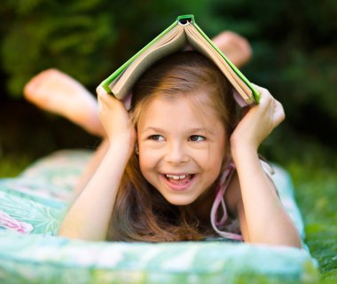 küçük kız açık havada kitap altında saklanıyor어린 소녀가 야외에서 책 아래에 숨어