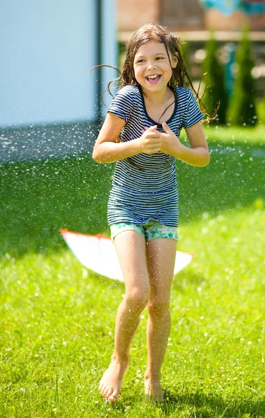 Menina feliz está jogando sob a chuva — Fotografia de Stock