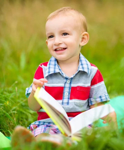 Liten pojke läser bok — Stockfoto