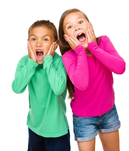 Klein meisje en jongen houden hun gezichten — Stockfoto