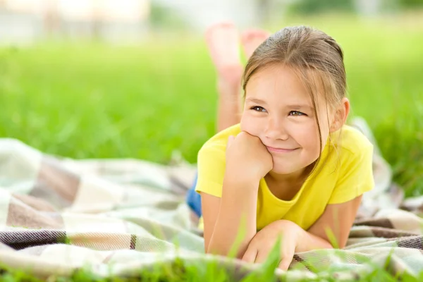 Portrait d'une petite fille allongée sur de l'herbe verte — Photo