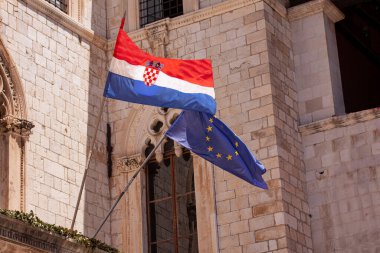 Hırvat ve AB Avrupa Birliği bayrakları eski Dubrovnik kasabasındaki inşaattan el sallıyor. Hırvatistan, 2013 yılında Avrupa Birliği 'ne katılan en genç ülke oldu.