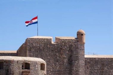Hırvatistan 'ın Dubrovnik kentinin duvarlarından gelen rüzgarda dalgalanan Hırvat bayrağı.