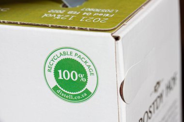 100 percent recyclable logotype on cardboard package. Close up photo with selective focus and shallow depth of field. Copenhagen, Denmark - July 31, 2022. 