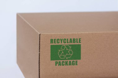 Cardboard pakage with printed recycling symbol. Photo with white background.