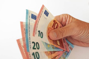 Hand holding range of Euro banknotes. Close up image isolated on white background. Expenses and incomes in European countries.Euro currency exchange rate. Cost of goods in EU.