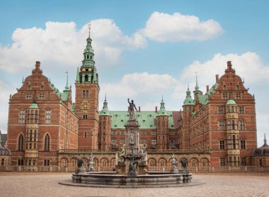 Danimarka 'daki Frederiksborg Kalesi. Önünde Neptune Çeşmesi var. 17. yüzyılın başlarından kalma saray. Mavi gökyüzü resmi. Kopenhag, Danimarka - 29 Eylül 2022.