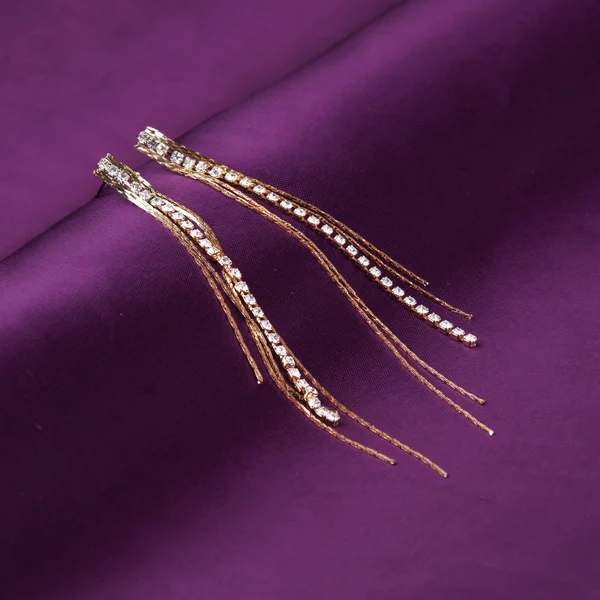 Ohrringe auf lila Hintergrund — Stockfoto