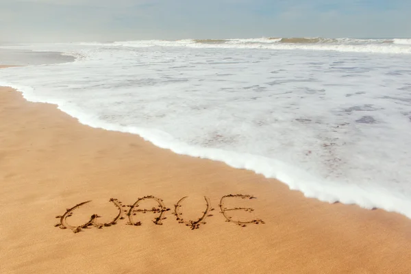 Ein Wort Welle auf Sand geschrieben — Stockfoto