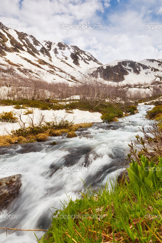 View to snow on Caucasus mountains over motion blurred stream ne
