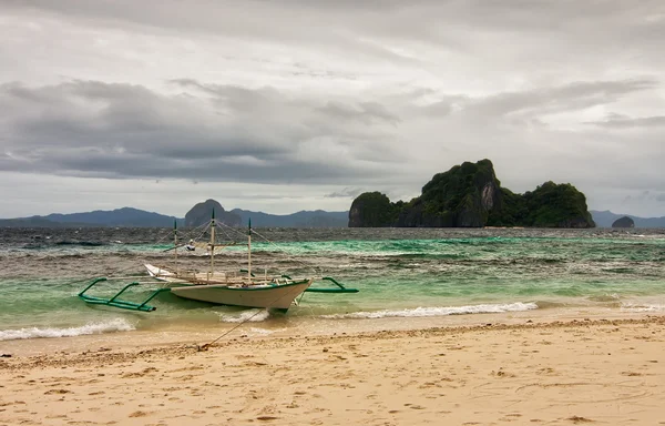 Båt till stranden vid stormigt väder under tunga moln — Stockfoto